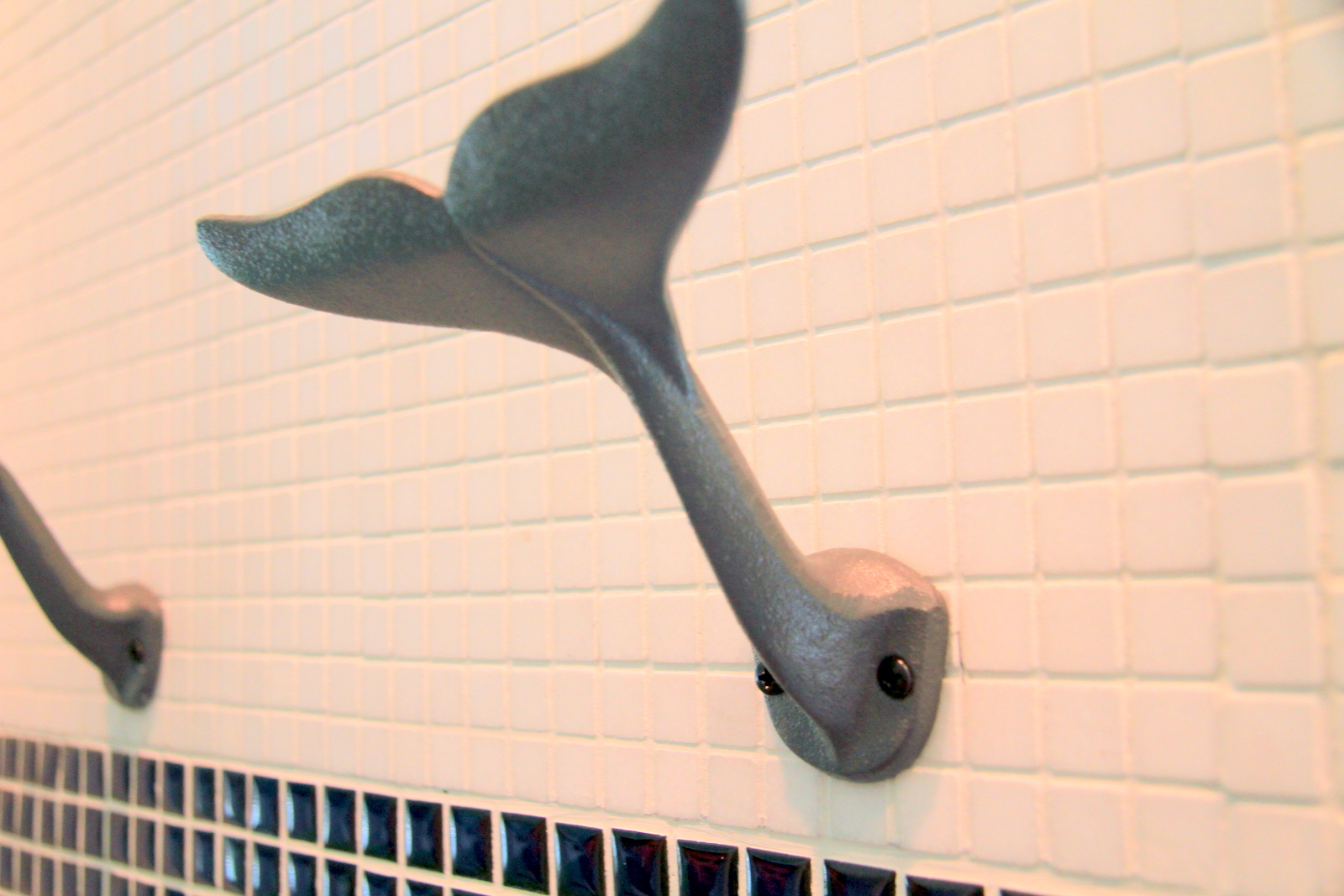 A whale towel hanger is beautifully placed to accent our Coastal bathrooms.